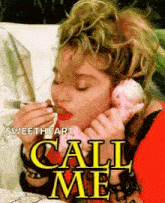 a woman is eating a donut while talking on a pink telephone .