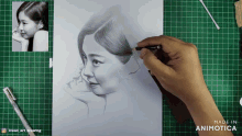a person is drawing a woman 's face on a green cutting board