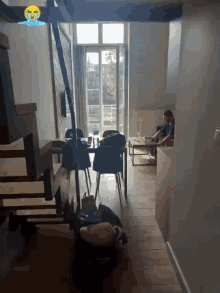 a man sits at a table in a living room with a crying face on the ceiling