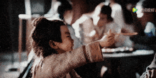 a little boy is holding a chopstick in front of a screen that says ' ao ' on it
