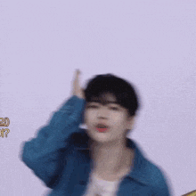 a blurry picture of a man wearing a blue jacket making a funny face .