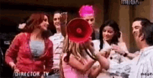 a group of people are standing around a woman with a megaphone in her hand .