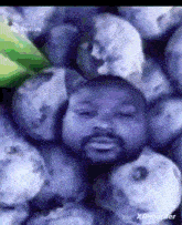 a bunch of blueberries with a man 's face on top