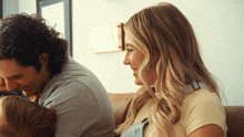 a man and a woman are sitting on a couch with a child