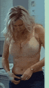a woman in a bra is putting on her pants