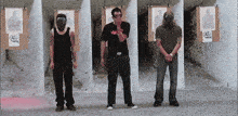 three men are standing in front of a shooting range with targets that say 45