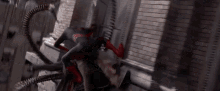 a man in a spiderman suit is fighting a octopus in a city .