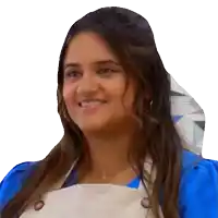 a woman in a blue shirt and white apron smiles