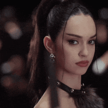 a close up of a woman 's face with a choker and earrings
