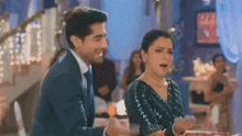 a man and a woman are standing next to each other in a room and laughing .