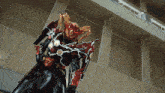 a robot with a helmet that looks like a dragon is standing in front of a wall