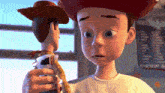 a close up of a toy story character holding woody doll
