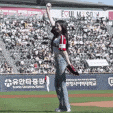 a woman throws a baseball in front of a sign that says yuanta securities