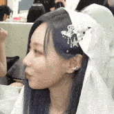 a woman with blue hair wears a white headband with a star on it