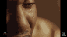 a man is crying with a tear coming out of his eye .