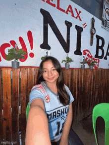a girl taking a selfie in front of a sign that says relax