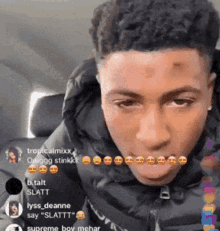 a young man in a black jacket is sitting in a car and looking at the camera .