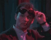 a man wearing sunglasses and a suit says deal with it .