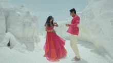 a man and a woman are dancing together and the woman is wearing a pink outfit .