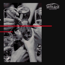 a black and white photo of people toasting with wine glasses and the words união veiculos
