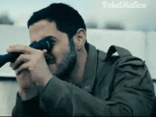 a man is looking through a telescope with the words petal malice in the corner