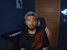 a man wearing headphones and a necklace giving the middle finger
