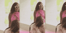 a woman in a pink dress and white sunglasses is standing in front of a mirror