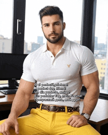 a man wearing a white polo shirt and yellow pants is sitting at a desk