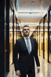 a man in a suit and tie is standing in a dark hallway