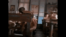 a group of children are sitting at their desks in a classroom in a dark room .