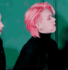 a man with pink hair is wearing a black shirt