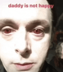 a close up of a man 's face with red eyes and the words daddy is not happy