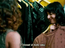 a woman in a closet talking to another woman