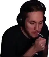 a man is smoking a cigarette while wearing headphones .