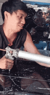 a man is holding a gun and smiling while using it