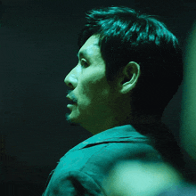 a man with a beard in a dark room with a green light behind him