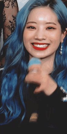 a close up of a woman with blue hair smiling