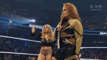 two women are standing in a wrestling ring with a banner that says mack be on it
