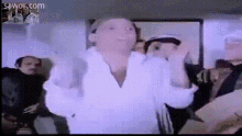 a man in a white shirt is standing in front of a group of people with sawor.com in the corner