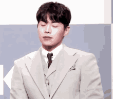 a man in a suit and tie is making a face with his eyes closed