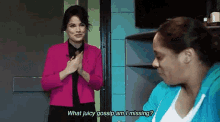 a woman in a pink jacket is standing next to another woman in a blue jacket and talking .
