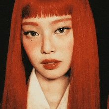 a close up of a woman 's face with long red hair and a white shirt .