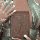 a woman is holding a bible with a cross on it in front of her chest .
