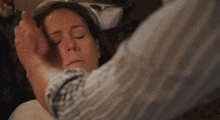 a woman with her eyes closed is being held by a man 's hand