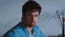 a man in a blue shirt is looking down at something