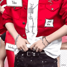 a person wearing a red jacket and a white shirt with a skeleton on it has a name tag that says school kills