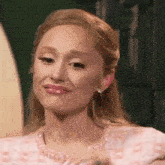 a close up of a woman wearing a pink dress and earrings .