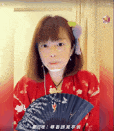 a woman in a red kimono is holding a fan with chinese writing on it