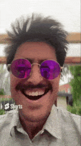 a man with a mustache is wearing sunglasses and making a funny face .