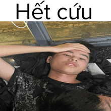 a young man laying down with his hand on his forehead and the word het cuu above him